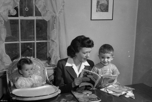 Mary Kessenich Schmitz, sitting with her children Martha and David, looking at garden seed catalogs.