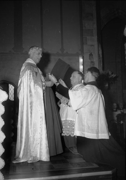 Rt. Rev. Msgr. Bernard G. Traudt, Milwaukee, conferring the rank of monsignor with title of right reverend on St. Bernard's pastor, William Eggers. Assisting in the ceremony is Rev. A.G. Schaeffer, St. James Church. 
