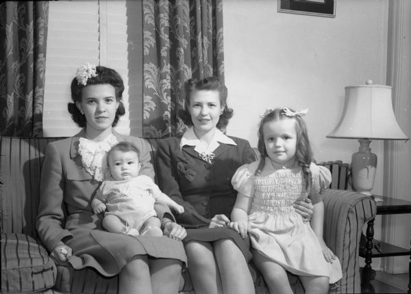 Two sisters, Marjorie Novotny Holt, with 5 month old son Stephen, and Norma Novotny Shorey, with 4 1/2 year old daughter Margie Kay. They were typical of many young wives and mothers who were anxiously awaiting the end of the war and return of their husbands from overseas.