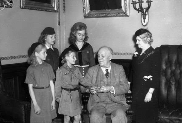 Group portrait of Governor Walter Goodland, a Scout leader, Mrs. Goodland and four Girl Scouts, in the Governor's office. Front row left to right: Dorothy Frederick, Dorothy Garvey, and back row left to right: Jean Podell, and Luanne Dreher.