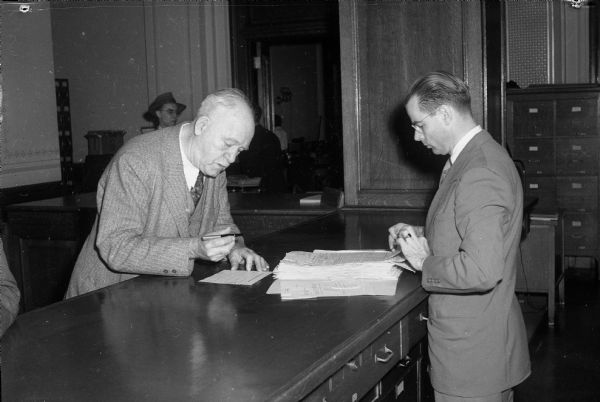 Governor Walter S. Goodland filing nomination papers at the Secretary of State Office with Gaige E. Roberts, chief of the elections and records division.