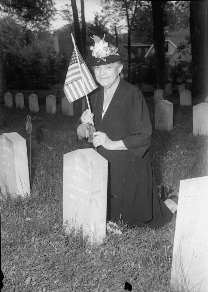 Ella Bennett Bresee, a member of one of Madison's oldest families, has decorated the graves of American war veterans for 70 years or more. She is placing an American flag on the grave at Confederate Rest. She died in October 1948.