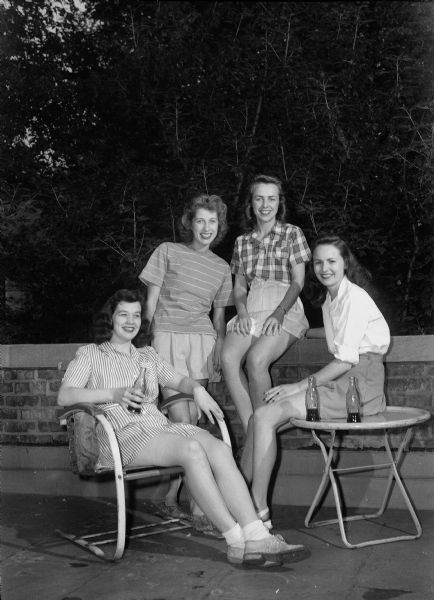 Four Gamma Phi Beta graduates relaxing after completing final exams. Left to right: Marion Grinde, DeForest, Betty Nelson, Neenah, Barbara Fletcher, Joliet, Illinois, and Sally Diener, Elmhurst, Illinois.