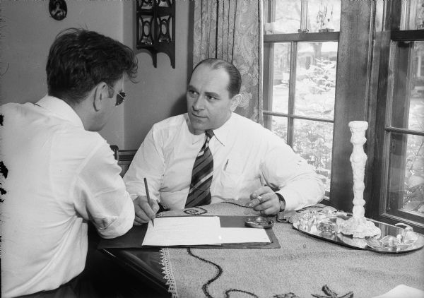 Louis H. Wagner with man discussing establishment of a youth center in Madison. Wagner is co-owner of the Campus Soda Grill, 714 State Street.