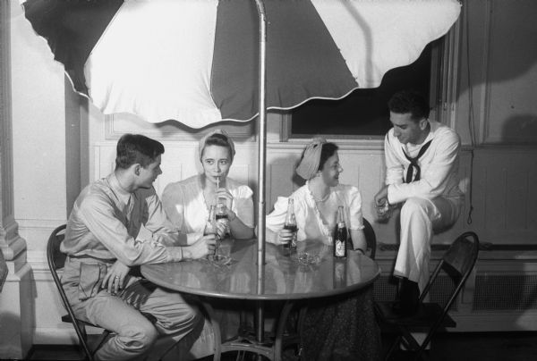 A Caribbean atmosphere is stressed at the Campacabana Club at the Memorial Union. Left to right: Pvt. Wheeler Ryall, Corpus Christi, Texas, and Romele Reddy, Madison, Nikki Wyles, Dumont, New Jersey, and Apprentice Seaman Chris Alexopoulous, Milwaukee.