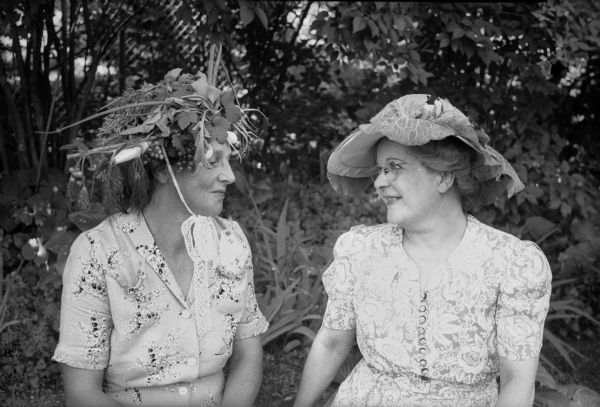 Two members of the West Side Garden Club wearing their hats created from vegetable material. From left: Mrs. Paul H. (Mary) Rehfeld, and Mrs. Thomas C. (Verna) McConnell.