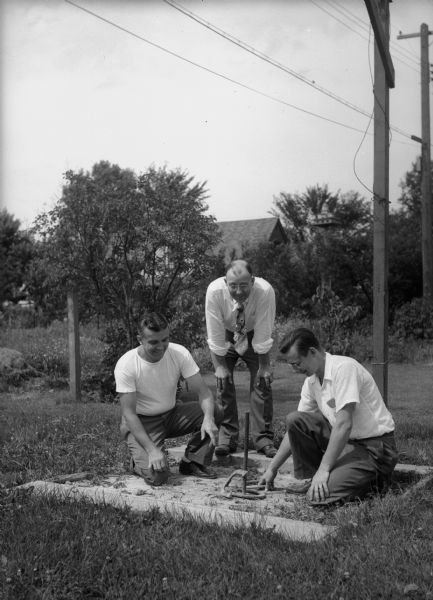 Fourth of July celebration in Westmorland neighborhood with three men pitching horseshoes. Shown here are Elmer Nielson, 4022 Winnemac Avenue, Ray Heibel, 4133 Paunack Avenue, and Robert E. Waterman, 3914 Mineral Point Road. Heibel is president of Westmorland Association, Neilson is in charge of baseball games at the picnic, and Waterman was the social chairman.