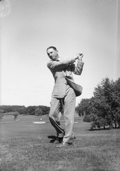 Kenneth W. Grafton, member of the firm Reitan-Lerdahl and Company, and secretary of the Nakoma Golf Club, swinging a golf club.