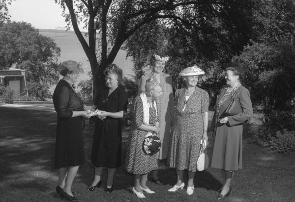 League of Women Voters garden party at the gubernatorial mansion. The following guests are standing the garden, left to right: Mrs. John E. Martin (Mary Martin), Mrs. Glenn W. Stephens (Helen Stephens), Edith Hoyt, Mrs. Dudley Montgomery (Josephine Montgomery), Mrs. John Donald, and Mrs. A.W. Shorger (Margaret Schorger).