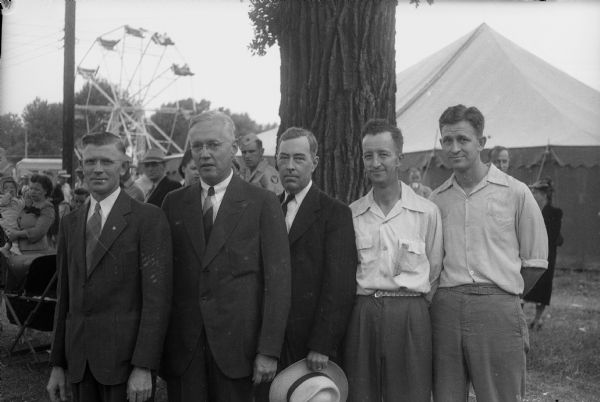 Five speakers at the Gisholt Machine Company picnic, taken at the Blooming Grove carnival grounds. Left to right: Marion "Red" Borland, president of Gisholt Workers' Union; George Johnson, president of the plant; Earl Mullen, Blooming Grove Town Board chairman; Warren Bass, outing chairman; and Norman Bass, former union president.