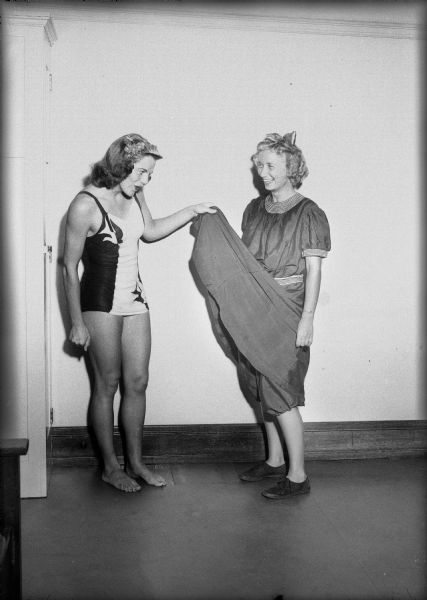 Nanette Taylor, dressed in current fashion suit, is viewing Betty Lippman dressed in 1903 style swim suit.
