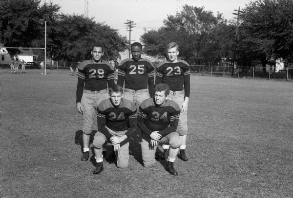 Group portrait of five Central High School football players: 29 Bernie Rabinowitz; 25 Ed Withers; 23 Ronald Caucutt; 24 Ed Moran; 34 Don Schiro.