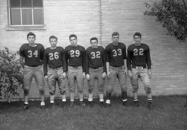 Group portrait of six Edgewood High School football players.  Standing from left: 34 Art Johnson, 26 Don Ryan, 29 Tom McCormick, 32 Ralph Riley, 33 Jim Mallatt, 22 Augie Strassman.
