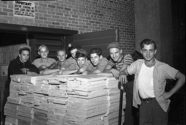 Eight high school students taking a few minutes off from their duties at Oscar Mayer and Company. From left: Kenneth Morrow, East High; Edward Wingen, East High; Bob Ringquist, East High; Floyd Myren, Vocational School; Bob Kirchesh, West High; Richard Schultz, Vocational High; Harold Hannemann, Lodi; Don Wiedemann, East High. These students divide their days between school work and work about town under a work-credit plan devised by the Board of Education, which is considered one of the foremost in the nation. This work-credit program using students was necessary due to the shortage of workers during World War II.