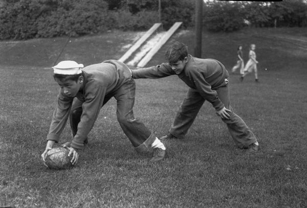 George Michaelson, Center, and Ted Blackney, Quarterback, practicing a play.  They are members of the West End Tigers midget football team.
