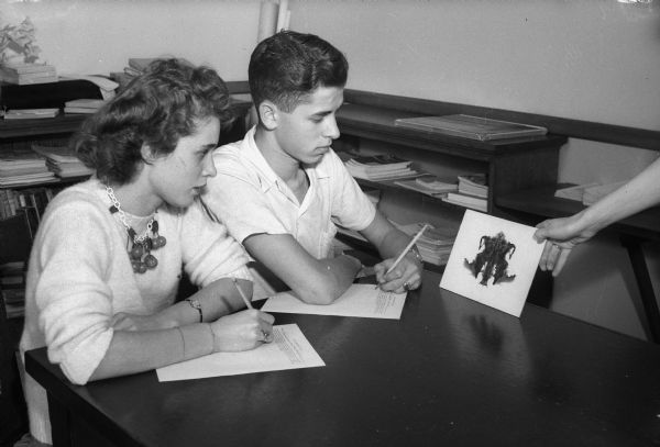 Two students, Gloria Schneider and Philip Loshek, both from Central High School, taking the Rorschach ink blot test as part of the vocational and social diagnostic testing offered by the Madison school system.