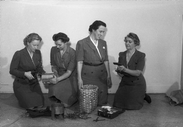 Officers of the Scout Leaders Club learning to build fires, making tin can stoves, and using outdoor equipment. Left to right are: Mrs. Eldred Tygum (Willna), Girl Scout Leader at Dudgeon School; Mrs. Harold Hennig,(?) leader at Randall School; Mrs. Fred C. Seibold,(?) head of Troop 25 at West Junior High School, and Mrs. C.B. Woodford (Mary), leader of another troop at West Junior High School.