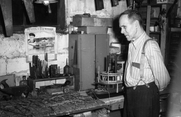 Captain Harry Dyer, age 80, admiring his model log raft and steam boat in his basement workshop. For 20 years he was a raft boat mate. He left the river in 1902 and for years worked as an engineer in the power plant which supplies the capitol building.