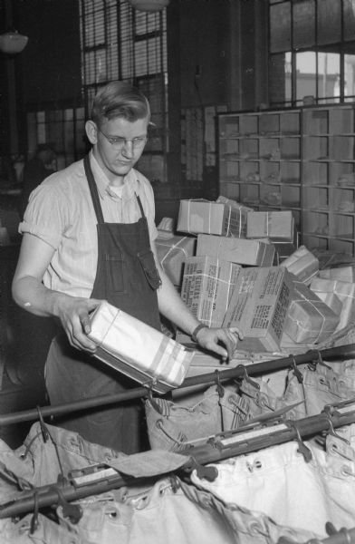 Clerk at the post office sorting Christmas parcels to be shiped overseas to men and women in service.