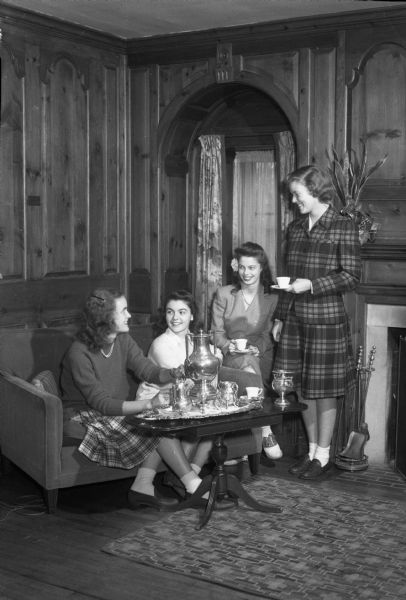 Gathering of four student pledges of Delta Gamma sorority of the University of Wisconsin, having tea during their visit. The pledges include Mary Bringardner, Columbus, Ohio; Judith Clark, Burlington, Iowa; Sally Conlin, daughter of Mr. and Mrs. W.H. Conlin, Madison; Anne Blakeley, Chester, Pennsylvania.