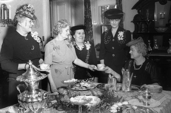 Officers of the Wisconsin Business and Professional Women's Club attending a tea at the Governor's Residence, 130 E. Gilman Street. Left to right around the serving table are: Mrs. Mabel R. Holdhusen, Madison, president of the state organization; Mrs. Walter (Madge) Goodland, wife of the Governor; Miss Christine Christenson, Marinette, first vice-president and state membership chairman; Dr. Helen Calmes, Appleton, second vice-president and public affairs chairman; and Miss Norma Howarth, Madison, a past state president.
