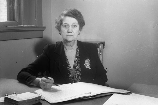 Miss M. Pearl Guynes, member of the Business and Professional Women's Club and recently appointed sergeant of the Madison Police Department, sitting at her desk.