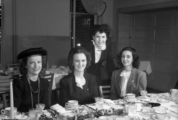Four officers' wives at the Madison Army Officers' Wives club meeting held at the Capital Hotel. From left to right: Mrs. E.F. Bond, Mrs. Stephen Garrett, Mrs. Douglas McAusland, and Mrs. Jerry Brannan.