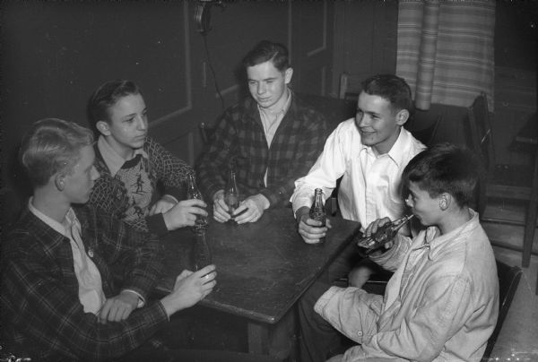 Five boys gathered around the table at the opening of the LOFT youth center. Left to right: Gordon Findorff, Maple Bluff; Dick Sandersen, 919 Vilas Avenue; Frank Ross, Shorewood Hills; Fritz Steinhauer, Lakewood; Peter Conlin, Maple Bluff.