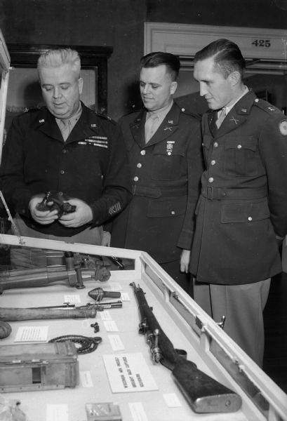 Brigidier General Ralph E. Immell, visiting the World War I room in the State Historical Society Museum with Lieut. Col. Franklin W. Clarke, commandant, Military Department of the University of Wisconsin, and Capt. Ray J. Sandegren, ROTC instructor from Tacoma, Washington.