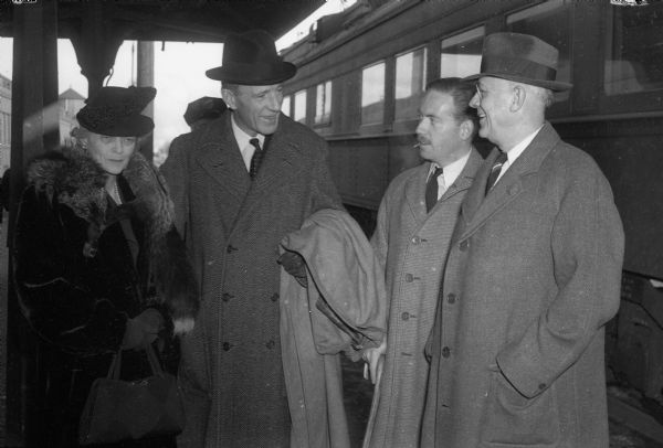 Ambassador Lord (Edward Frederick Lindley Wood) and Lady Halifax, British ambassador to the United States, at the train station. Left to right: Lady Halifax, Lord Halifax, Lieut. Richard Wood, their son, and President Clarence A. Dykstra. Lord Halifax will speak at the University of Wisconsin at the Wisconsin Union Theater.