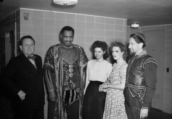 Two Madison women appearing in the Margaret Weber's production of "Othello", at the Wisconsin Union Theater with other cast members and Professor Oskar F.L. Hagen of the University of Wisconsin Art History department. Left to right: Professor Hagen, Paul Robeson appearing as Othello, Barbara Anderson who has a minor part, Uta Hagen (daughter of Professor Hagen), appearing as Desdemona, and Jose Ferrar, Miss Hagen's husband, who appears as Iago. Mr. Robeson and Mr. Ferrar are in costume.