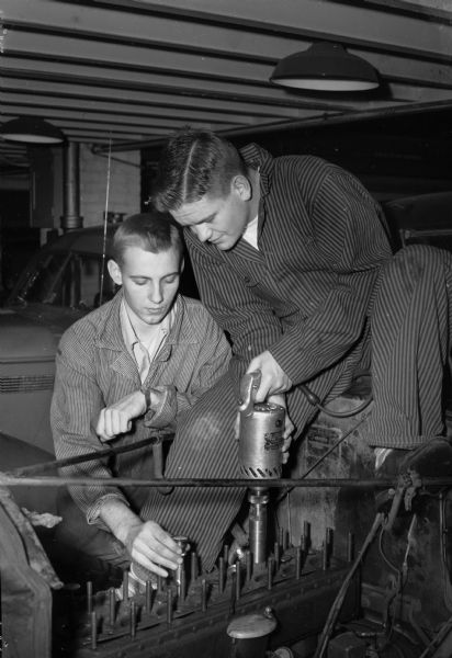 Automotive Mechanics class at East High School. Pictured are Irving Smith with a power driven valve seat grinder, and Bob Koltes checking his work.