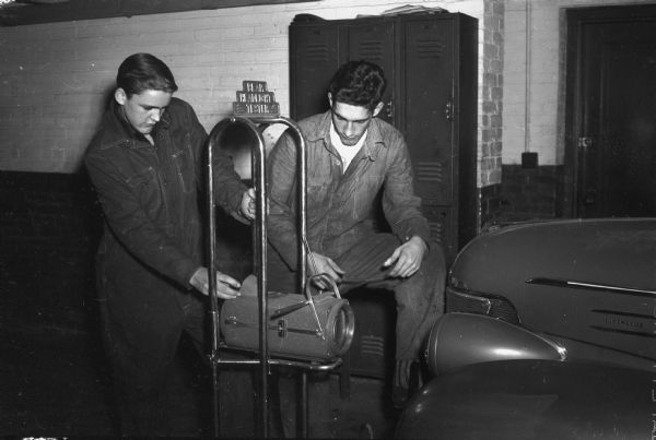 Automotive Mechanics class at East High School. Ralph Preez and Bob Mattison are checking a set of headlights.