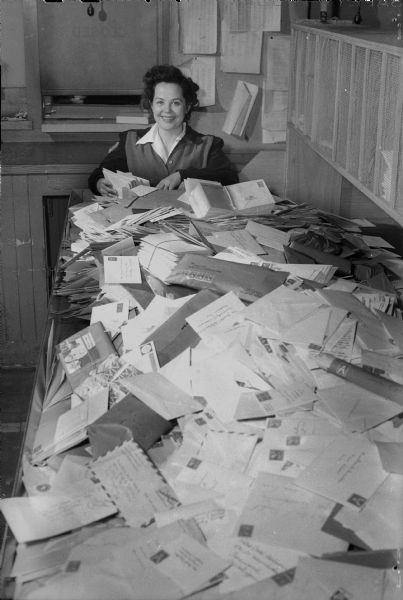 Mrs. R.S. Briggs, postal clerk, with Christmas cards and packages.