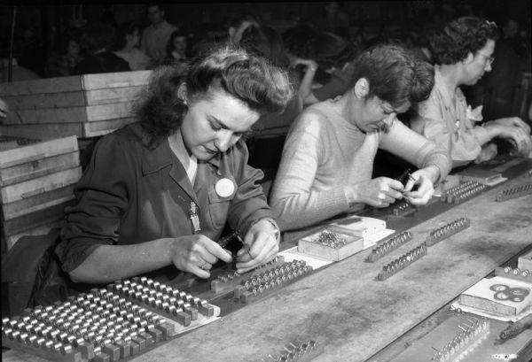 Lorraine Gray and Mrs. Mildred Lewis on the production line at the RMR (Ruben-Mallory-Ray-O-Vac) plant, a division of Ray-O-Vac located in the 1400 block of East Washington Avenue. The plant manufactured batteries for walkie-talkies used for the military during World War II.