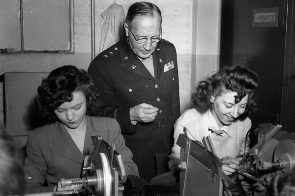 Maj. Gen. Harry C. Ingles, Chief Signal Officer, United States Army, watching two women make batteries at Ray-O-Vac, or RMR (Ruben Mallory Ray-O-Vac).