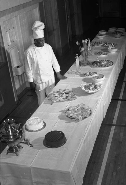 Elevated view of chef Carson Gulley, standing behind a buffet table.