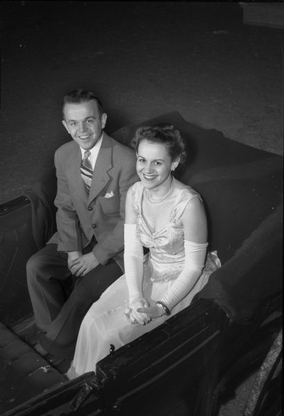 Richard Halbach and Florence Bahr, sitting in a car, are the King and Queen of the 26th annual Little International Livestock and Horse Show, held in the Stock Pavilion on the Agricultural campus of the University of Wisconsin-Madison. The event is sponsored by the Saddle and Sirloin Club.