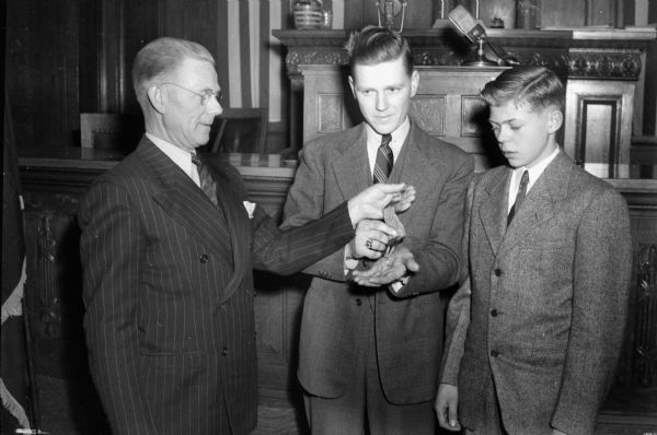 Axel Olson with his sons Earl and Richard inspecting the Congressional Medal of Honor awarded posthumously to son and brother Sgt. Truman O. Olson. Truman was killed at Anzio, Italy, during World War II.
