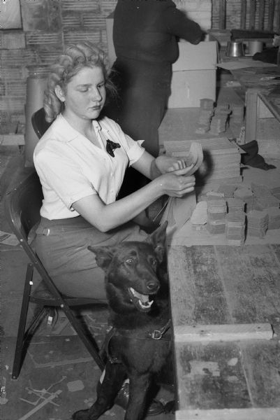 Jeanne DeBarr, a blind employee working at Forsberg Box Company, with her dog.