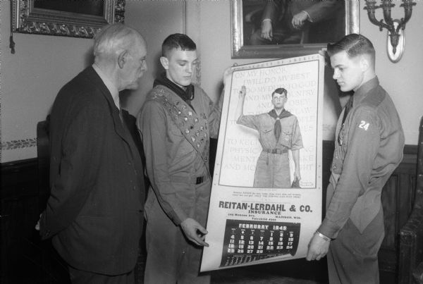 Wisconsin Governor Walter S. Goodland and two unidentified Boy Scouts with a Reitan-Lerdahl calendar.