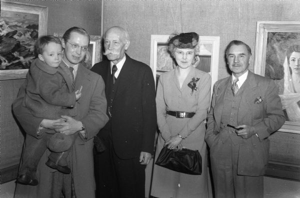 Winners of high awards and prizes at the sixth Madison Artists exhibition. Left to right: Robert Schellin is holding his son Peter, Oscar F. Mayer Purchase Prize; Julius Rehder, Best Oil Painting in the Show; Mrs. Rose Kennedy, also winner of the Oscar F. Mayer Purchase Prize; and Prof. Roland S. Stebbins, whose group of four oil paintings was judged the most meritorious work.
