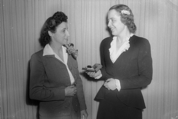 Mrs. Marie Haight, 437 North Ingersoll Street, on the left, and Mrs. W.C. Dunn, Shorewood Hills. Mrs. Haight, a teacher at Shorewood School, is being presented a gold watch by Mrs. Dunn on behalf of the students for her seventeen years of service. Mrs. Haight is leaving Shorewood School to teach at Lapham School.
