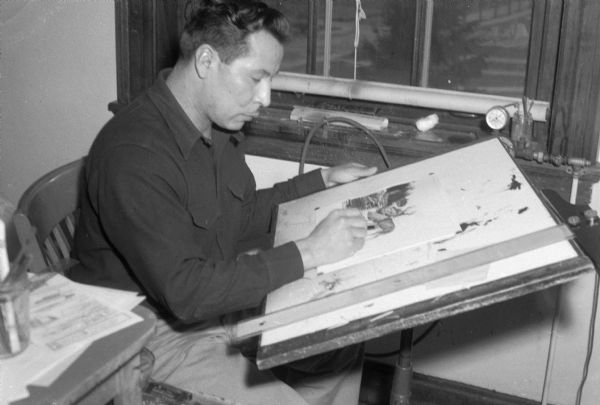 Native American artist working at an easel, taken for WHA, the Wisconsin State radio station.