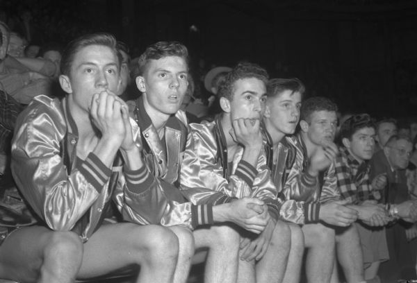 West High School basketball team reserve players sitting on the team bench during a game at the annual state basketball tournament.  Left to right are: Harold Carpenter, John Berger, Jim Zimmerman, Ray Lenahan, and Tom Callen.