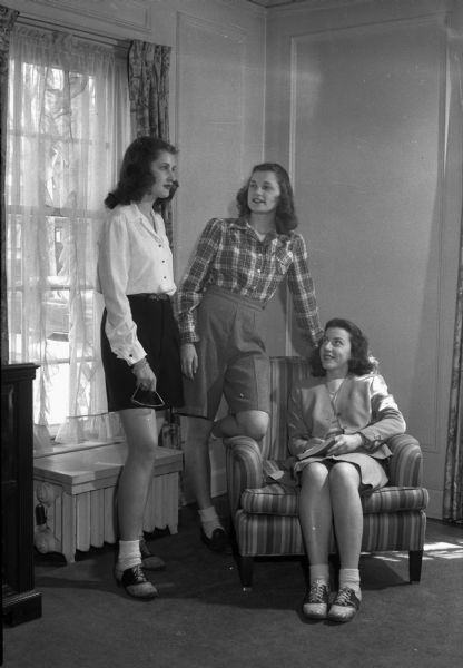 Three University of Wisconsin coeds modeling clothes for a fashion show sponsored by the Women's Student Government Association. This year's show, held on March 29, will stress the theme of utility clothes for a useful wartime life.