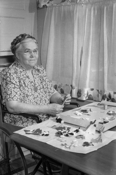 Mrs. Eda Haugsland, 207 North Pinckney Street, sewing lapel decorations for the Dane County homework shops which employ persons with disabilities.