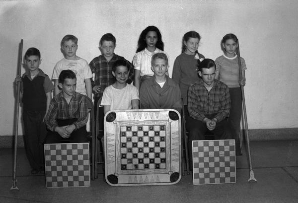 Group portrait of ten children with game boards illustrating activities sponsored by Madison School Community Recreation activities.