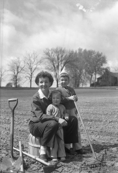 Mrs. Karl L. Siebecker and her children, Judy (left) and Susan (right), in their Community Union garden on Arlington Place. The gardens are planned to provide garden space for Madison residents who do not have sufficient areas at their homes in which to raise generous supplies of vegetables. The 26 acres of Community Union gardens were used by more than 400 persons in 1944.