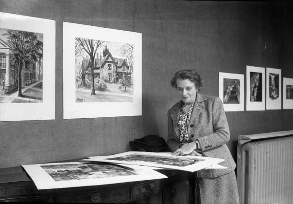 Winifred (Bonnewitz) Ford with several of her watercolor paintings from the exhibit at the State Historical Society of Wisconsin titled "Old Homes in Madison." The exhibit featured 36 famous old homes and buildings from the building "boom" in Madison before the Civil War.  Mrs. Ford was the widow of the veteran actor and theatrical producer Marcus Ford.